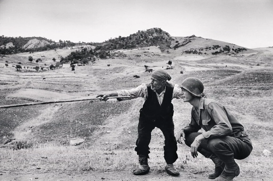 Un paysan sicilien indique à un officier américain la direction prise par les Allemands, près de
Troina en Sicile, Italie, Août 1943
Crédit : Robert Capa/
International Center of Photography/Magnum Photos