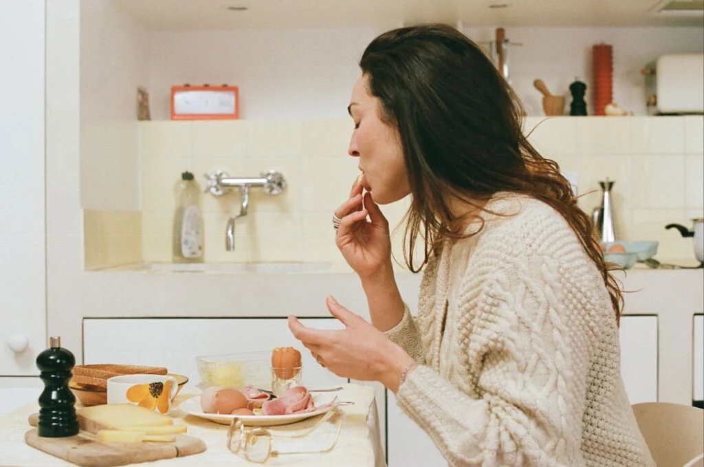 Une femme mange un oeuf