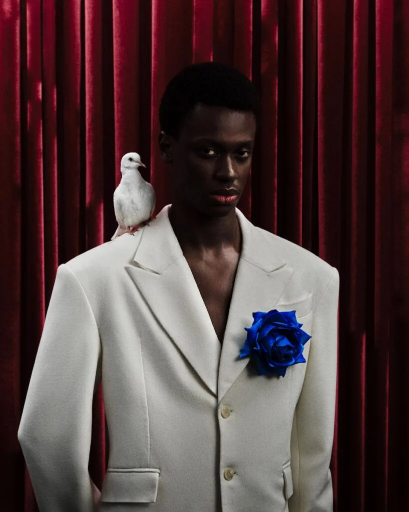 Portrait d'un homme avec un oiseau sur l'épaule et une fleur bleue à la boutonnière