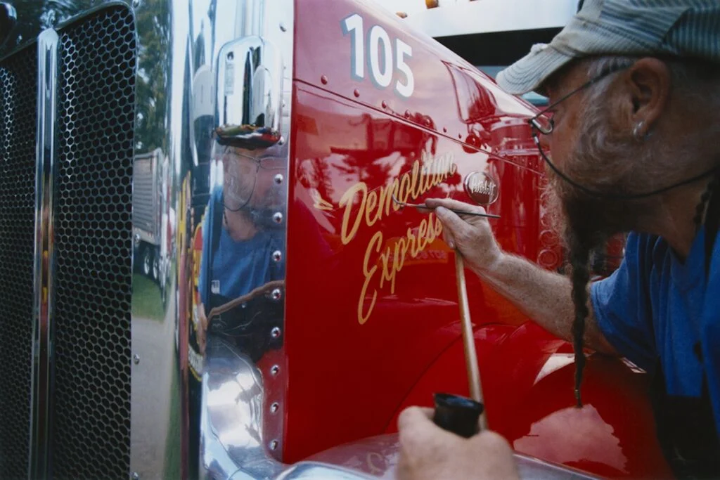 routier dessinant les lettres sur son camion