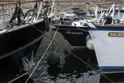Benoit · 13/09/2025 · 1500 x 1000 Cette photographie met en scène des bateaux amarrés dans un port. Le sujet principal est un bateau nommé **« Forever »**, avec un autre, **« Balade »**, en arrière-plan. La composition montre les coques et les mâts, avec un cadrage serré sur l’eau et les détails des navires.La lumière semble naturelle, bien que légèrement tamisée, créant des ombres douces. Les couleurs dominantes sont les tons bleus et gris de l’eau et des bateaux, avec des touches noires et blanches. Le style est réaliste et documentaire, évoquant une ambiance calme et maritime, typique d’un port paisible.