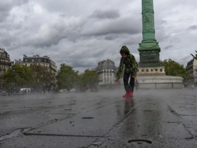 Cyrille · 13/09/2025 · 3840 x 2880 Cette photographie met en scène une personne en mouvement, vêtue d’un manteau vert et de bottes rouges, marchant sous une pluie fine. Le sujet principal est centré, avec en arrière-plan une colonne monumentale (probablement la colonne Vendôme à Paris).La composition est équilibrée, avec un cadrage serré sur le sujet et une perspective légèrement basse. La lumière est tamisée par les nuages, créant une ambiance grise et mélancolique. Les couleurs dominantes sont les tons froids (gris, bleu) adoucis par les touches de vert et rouge du manteau.Le style est réaliste et documentaire, évoquant une atmosphère calme et contemplative.