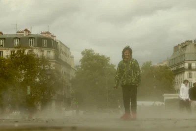 Francoise · 13/09/2025 · 3840 x 2560 Cette photographie met en scène une personne vêtue d’un manteau vert et d’un chapeau, debout au centre d’une rue embrumée. La composition est symétrique, avec le sujet légèrement isolé par la brume.Le cadrage est serré sur le personnage, avec des bâtiments et des arbres en arrière-plan. La lumière est diffuse, atténuée par le brouillard, créant une atmosphère mystérieuse et mélancolique. Les couleurs dominantes sont les tons grisâtres et verts, renforçant une ambiance froide et onirique. Le style rappelle un réalisme poétique, évoquant une scène presque surnaturelle.
