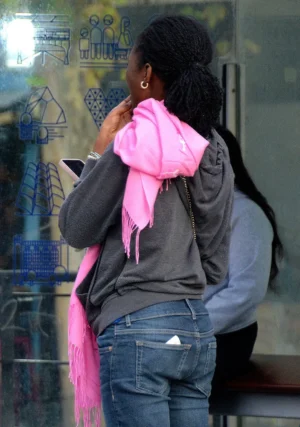 Pascale · 17/10/2025 · 703 x 1000 Cette photographie montre une personne vue de dos, portant un sweat-shirt gris et un sac à dos avec une écharpe rose vif. Le sujet principal est flou, suggérant un mouvement ou une attention portée ailleurs.La composition est simple, centrée sur la silhouette. Le cadrage est serré, mettant en valeur les détails du haut du corps. La lumière semble naturelle, avec des ombres douces. Les couleurs dominantes sont les tons gris et bleu du fond, contrastés par le rose éclatant de l'écharpe.Le style est documentaire et spontané, créant une ambiance moderne et urbaine.
