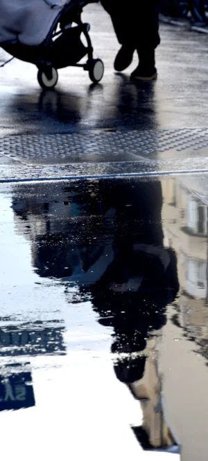 Pascale · 04/10/2025 · 887 x 1960 Cette photographie capture une réflexion dans une flaque d’eau. Le **sujet principal** est un homme marchant, visible à la fois dans la réalité et son reflet inversé. La **composition** joue sur la symétrie et la dualité. Le **cadrage** est serré, centré sur les pieds et la flaque, créant un effet de miroir intrigant.La **lumière** semble naturelle, avec des contrastes doux, et les **couleurs dominantes** sont des tons neutres (gris, noir, blanc), adoucis par des reflets bleutés. Le **style** est épuré et minimaliste, évoquant une **ambiance** contemplative et presque onirique, mêlant réalité et illusion.