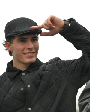 Mary · 15/11/2025 · 2227 x 2784 Cette photographie met en scène un jeune homme comme sujet principal. Il porte un chapeau noir et une veste assortie, avec un sourire détendu. Le cadrage est serré, centré sur son visage et ses gestes expressifs (il ajuste son chapeau).La lumière semble naturelle et douce, sans ombres marquées, créant une ambiance lumineuse et claire. Les couleurs dominantes sont les tons noirs de ses vêtements et le gris clair de l’arrière-plan, renforçant un style sobre et moderne. L’ambiance est décontractée et joyeuse, évoquant une sensation de simplicité et de naturel.