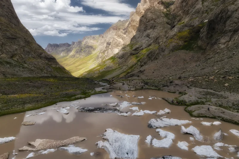 Ahmet · 14/07/2025 · 3000 x 2000 Cette photographie met en scène un **ruisseau de montagne** bordé de glace et de rochers, dans un **canyon escarpé**. Le **sujet principal** est le contraste entre l’eau boueuse et les blocs de glace.La **composition** est dynamique, avec un **cadrage serré** sur le cours d’eau, encadré par des parois rocheuses imposantes. La **lumière**, naturelle et douce, souligne les textures et les ombres, créant un jeu de clarté et de pénombre. Les **couleurs dominantes** sont les tons froids (blanc de la glace, gris des rochers) et des teintes terreuses (brun de l’eau).Le **style** est réaliste et documentaire, évoquant une **ambiance sauvage et minérale**, presque mystique.