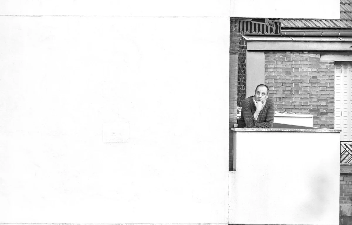 AnJo · 09/05/2020 · 4302 x 2755 Cette photographie en noir et blanc met en scène un homme assis sur un rebord de fenêtre, tenant un objet plat. Le sujet principal est centré dans un cadrage serré, encadré par l’architecture d’un bâtiment en briques.La composition est simple et épurée, avec un jeu d’ombres et de lumière naturelle qui accentue les contours. L’ambiance est sobre et introspective, renforcée par le contraste des teintes claires et sombres. Le style, dépouillé et minimaliste, évoque une touche documentaire ou artistique vintage, créant une atmosphère à la fois mélancolique et contemplative.