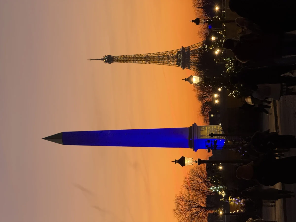Deniz · 27/12/2024 · 4032 x 3024 Cette photographie met en scène la Tour Eiffel, sujet principal, avec une superposition créative d’un avion stylisé en bleu. La composition joue sur l’horizon où la tour est partiellement cachée par un ciel orangé. Le cadrage est serré sur la base de la tour, accentuant la silhouette de l’avion.Les couleurs dominantes sont les tons chauds du coucher de soleil (orange, jaune) contrastant avec le bleu électrique de l’avion. La lumière douce crée une ambiance onirique et mélancolique, mêlant réalité et imagination. Le style est artistique et poétique.
