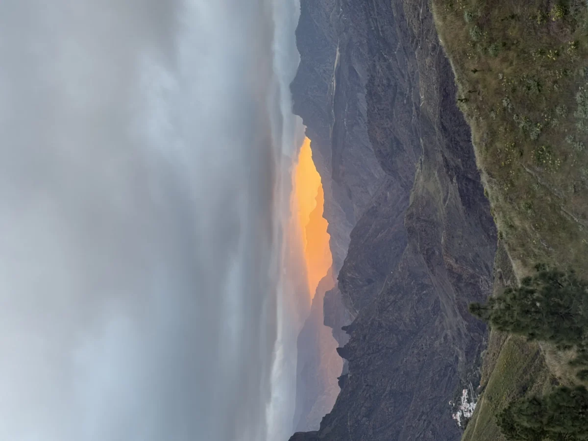 Deniz · 30/04/2025 · 4032 x 3024 Cette photographie capture un coucher de soleil spectaculaire derrière une chaîne montagneuse. Le **sujet principal** est la lumière dorée et orangée qui traverse les nuages, éclairant les sommets.La **composition** est simple et épurée, avec un **cadrage** large mettant en valeur les reliefs montagneux. La **lumière** est douce et diffuse, créant des contrastes entre ombres et éclats lumineux. Les **couleurs dominantes** sont les tons chauds (orange, jaune) et les teintes bleutées des nuages et montagnes.Le **style** est naturel et réaliste, évoquant une **ambiance** paisible et majestueuse, presque mystique.