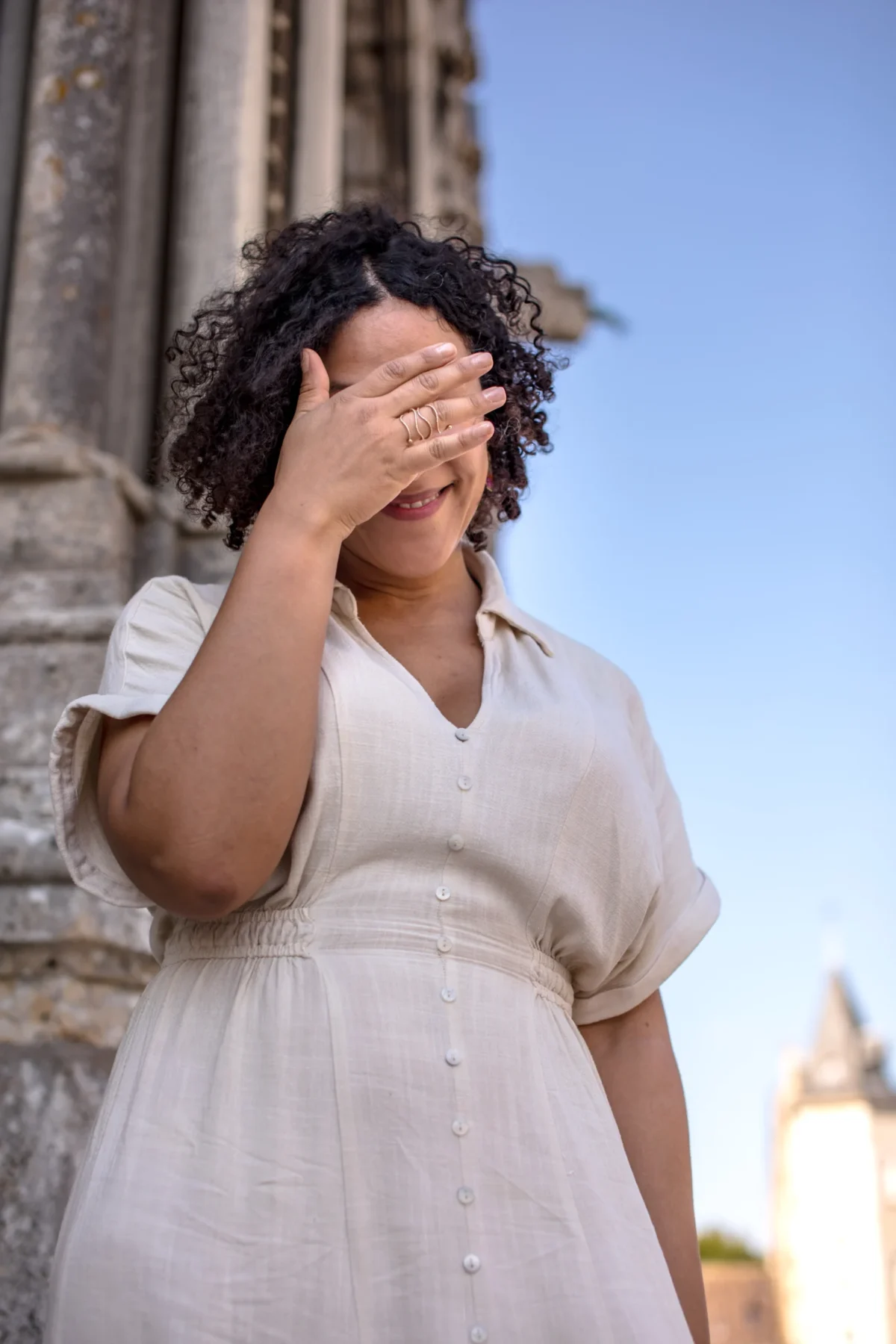 Tery · 4480 x 6720 Cette photographie met en scène une femme comme sujet principal, vêtue d'une robe claire et couvrant ses yeux d'une main. La composition est simple et centrée, avec un cadrage serré sur son visage et son haut.La lumière est douce et naturelle, probablement en extérieur, créant des ombres légères. Les couleurs dominantes sont des tons neutres et pastel, avec des touches de blanc et de bleu pâle en arrière-plan.Le style est épuré et intime, évoquant une ambiance à la fois mystérieuse et poétique.