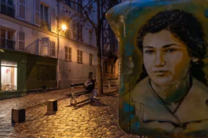 Marc · 20/12/2025 · 6241 x 4161 Cette photographie présente une **composition divisée** entre un **sujet urbain nocturne** et un **portrait en médaillon**.À gauche, le **cadrage** montre une rue pavée faiblement éclairée, avec des bâtiments anciens et une personne assise sur un banc. La **lumière** est douce et tamisée, créant une ambiance calme et mélancolique.À droite, le **portrait** en médaillon, aux **tons sépia**, ajoute une touche historique et intime. Les **couleurs dominantes** sont des teintes chaudes (beige, marron) et des nuances nocturnes (gris, bleu nuit).Le **style** mêle réalisme et nostalgie, évoquant une **ambiance contemplative et poétique**.