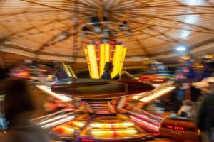 Marc · 20/12/2025 · 7008 x 4672 Cette photographie capture un manège ou une attraction foraine en mouvement. Le sujet principal est le centre tourbillonnant, flou par effet de vitesse, avec des couleurs vives et lumineuses. La composition met en avant des éléments circulaires et des motifs géométriques.Le cadrage est serré, centré sur le mouvement et les lumières. Les couleurs dominantes sont les jaunes, rouges et bleus, créant une ambiance dynamique et festive. Le style est cinétique, avec des traces de lumière et de mouvement, évoquant une sensation de vitesse et de joie. L'ambiance est joyeuse et énergique, typique d'une fête foraine.
