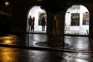Benoit · 20/12/2025 · 5204 x 3469 Cette photographie capture un groupe de personnes entrant sous une arche éclairée la nuit. Le sujet principal est l’architecture et les silhouettes en mouvement. La composition repose sur une perspective symétrique avec des arcs en pierre et un sol pavé mouillé reflétant la lumière.Le cadrage est serré, mettant en valeur les jeux d’ombres et de lumières. Les couleurs dominantes sont les tons froids (gris, bleu nuit) et les éclairages jaunes chauds. Le style est réaliste et légèrement dramatique, renforcé par les contrastes lumineux. L’ambiance est nocturne et mystérieuse, évoquant une atmosphère calme et contemplative.