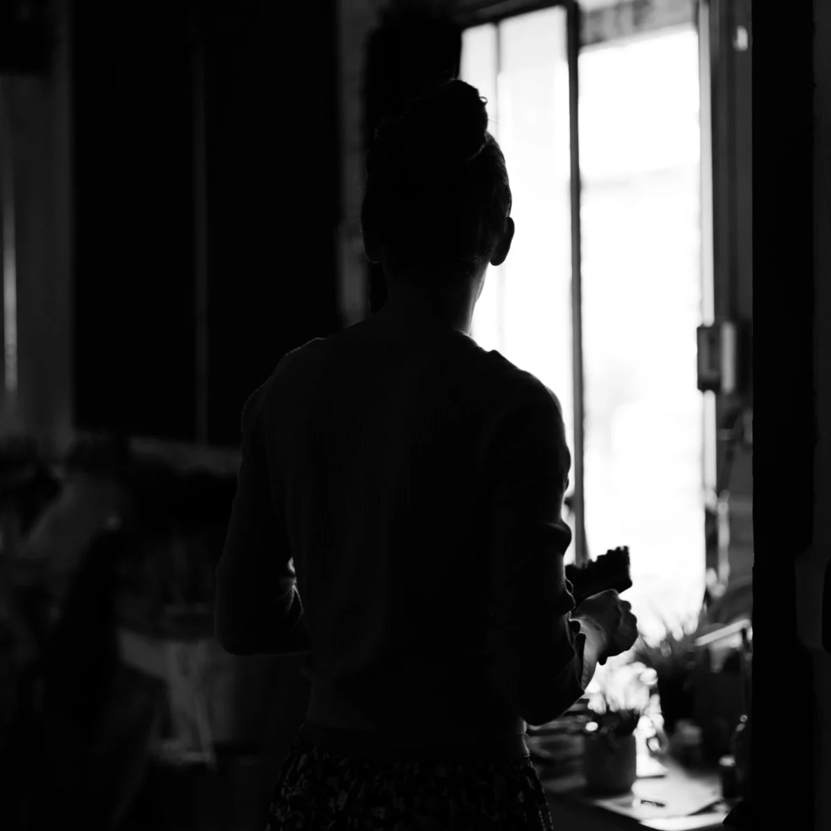 Olivier · 27/07/2024 · 3662 x 3662 Cette photographie en noir et blanc met en scène une silhouette féminine de dos, silhouette principale. La composition repose sur un cadrage serré et une lumière naturelle filtrée par une fenêtre, créant des contrastes forts entre ombres et clartés. L’ambiance est intime et contemplative, renforcée par les jeux de lumière douce.Les couleurs dominantes sont les tons de gris, typiques du noir et blanc. Le style est épuré et minimaliste, évoquant une atmosphère calme et mélancolique. L’arrière-plan flou et les détails comme les objets sur la table renforcent cette impression de simplicité et de sérénité.