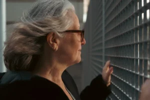 Don · 7008 x 4672 Cette photographie met en scène une femme âgée comme sujet principal, vue de profil. Elle porte des lunettes et observe attentivement une grille métallique.La composition est simple et centrée sur son visage et ses mains. Le cadrage est serré, mettant l'accent sur son expression et les détails de la grille.La lumière est douce et naturelle, éclairant son visage avec des ombres subtiles. Les couleurs dominantes sont des tons neutres, avec des gris et noirs prédominants.Le style est réaliste et sobre, évoquant une ambiance calme et introspective.