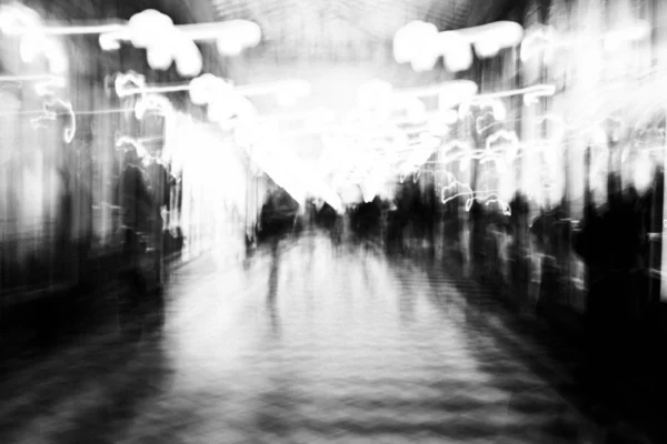 Thierry · 03/01/2026 · 3840 x 2560 Cette photographie en noir et blanc capture une scène floue et dynamique, probablement une rue ou un lieu public. Le sujet principal est suggéré par les silhouettes et les formes mouvantes, créant un effet de vitesse et de mouvement.La composition est symétrique avec une perspective centrale, guidant le regard vers l’horizon. Le cadrage est large, englobant une vaste étendue.La lumière est douce et diffuse, avec des contrastes atténués. Les couleurs dominantes sont les nuances de gris, renforçant l’ambiance onirique et mystérieuse. Le style est abstrait et artistique, évoquant une sensation de flou cinétique. L’ambiance est à la fois dynamique et mélancolique.