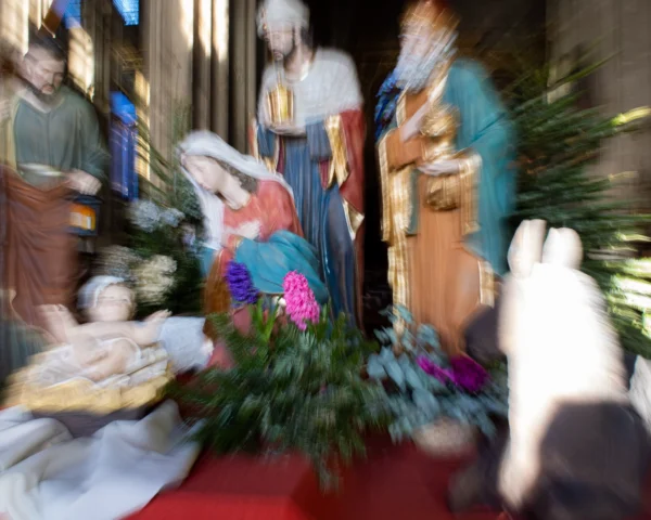 Loubna · 2048 x 1638 Cette photographie représente une scène de **nativité ou crèche**. Le **sujet principal** est la représentation de la naissance du Christ, entourée de figures traditionnelles comme Marie, Joseph et des animaux.La **composition** est serrée, avec un **cadrage rapproché** mettant en valeur les détails des personnages et des éléments décoratifs. Les **couleurs dominantes** sont douces, avec des tons pastel et des touches de vert (végétation) et de rouge (tapis).La **lumière** semble naturelle, tamisée, créant une ambiance chaleureuse et sacrée. Le **style** est réaliste et traditionnel, évoquant une **ambiance paisible et spirituelle**.