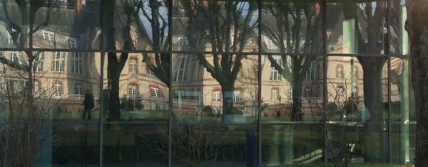 Laurence · 3472 x 1359 Cette photographie présente une vue fragmentée à travers une série de vitres ou miroirs, reflétant un parc urbain. Le sujet principal semble être les arbres dénudés et les bâtiments en arrière-plan, dont une cathédrale ou une église.La composition est géométrique et répétitive, avec des cadres multiples créant un effet de mosaïque. Le cadrage est serré et varié, capturant des angles différents.La lumière est douce, probablement naturelle, avec des tons chauds en fin de journée. Les couleurs dominantes sont des teintes neutres (gris, beige) et des touches de vert et brun.Le style est réaliste et légèrement abstrait, évoquant une ambiance calme et contemplative.