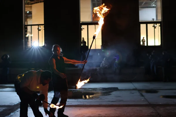 Laurence · 2825 x 1883 Cette photographie capture un artiste de feu en pleine performance. Le sujet principal est l’artiste manipulant des torches enflammées, entouré de flammes vives. La composition met en valeur son action centrale, avec un cadrage serré sur lui et son environnement immédiat.La lumière est dramatique, avec des éclats de feu contrastant sur les tons sombres de la nuit. Les couleurs dominantes sont les teintes chaudes des flammes (oranges, jaunes) et les ombres bleutées. Le style est dynamique et artistique, évoquant une ambiance spectaculaire et intense, typique des spectacles de rue ou des performances de feu.