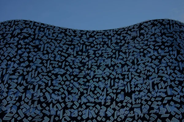 Paul C. · 17/01/2026 · 5979 x 3986 Cette photographie montre une surface texturée avec un motif complexe de petits caractères ou symboles noirs sur fond bleu clair. Le sujet principal semble être ce motif répétitif et dense.La composition est épurée, avec un cadrage serré qui met en valeur les détails. La lumière est douce et uniforme, sans ombres marquées, créant une ambiance apaisante. Les couleurs dominantes sont le bleu profond et le noir, renforçant un style minimaliste et presque abstrait. L’ambiance évoquée est à la fois mystérieuse et géométrique, avec une touche de modernité.