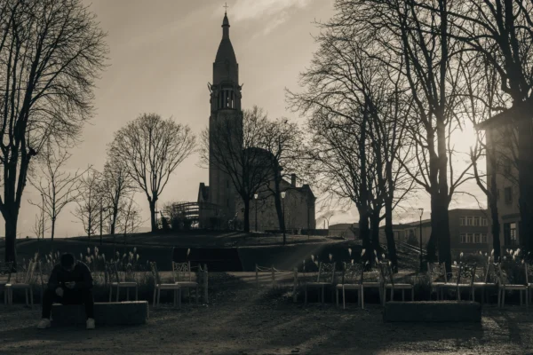 Don · 5459 x 3639 Cette photographie met en scène une église gothique imposante comme sujet principal, avec sa flèche centrale se détachant derrière des arbres dénudés. La composition joue sur les lignes verticales et horizontales, encadrant l'édifice entre les branches.Le cadrage est serré, créant une perspective dramatique. La lumière, douce et tamisée, donne une ambiance nostalgique et mélancolique. Les tons dominants sont les gris et noirs, renforçant l’aspect monochrome et dramatique. Le style, en noir et blanc, accentue les contrastes et les textures, évoquant une atmosphère à la fois historique et contemplative.
