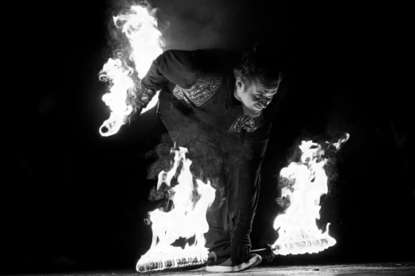 Don · 24/01/2026 · 3645 x 2430 Cette photographie met en scène un individu en train de marcher ou courir, entouré de flammes à ses pieds et mains, créant un effet spectaculaire. Le sujet principal est flou, mais les contours sont visibles grâce à la lumière.La composition est dynamique, centrée sur le mouvement et l'action. Le cadrage est serré, mettant l'accent sur les pieds et les mains du personnage. La lumière est dramatique, avec des contrastes forts entre les zones éclairées par les flammes et l'obscurité ambiante. Les couleurs dominantes sont les noirs et blancs, typiques d'une photo en noir et blanc, renforçant l'ambiance mystérieuse et intense. Le style est artistique et théâtral, évoquant une ambiance mystique et puissante.
