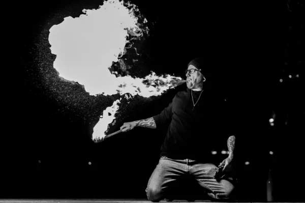 Don · 24/01/2026 · 6865 x 4577 Cette photographie met en scène un homme en train de souffler une fumée en forme de nuage, créant une silhouette expressive. Le sujet principal est centré, avec un cadrage serré qui isole son action.La composition joue sur les contrastes entre la forme organique de la fumée et les lignes droites du corps. La lumière est dramatique, avec un éclairage contrasté typique du noir et blanc, accentuant les ombres et les formes. Les couleurs dominantes sont les tons de gris, renforçant l’ambiance mystérieuse et artistique. Le style rappelle le photojournalisme ou l’art conceptuel, évoquant une atmosphère à la fois poétique et intrigante.