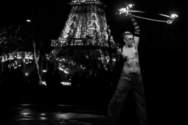 Don · 24/01/2026 · 5178 x 3452 Cette photographie en noir et blanc met en scène une personne, sujet principal, vêtue d’un costume traditionnel, manipulant des objets lumineux (probablement des bâtons de feu ou des lumières). La composition est dynamique, avec un cadrage serré sur le sujet, isolé sur un fond flou mais identifiable comme un lieu festif ou un temple illuminé.La lumière est contrastée, mettant en valeur le sujet par des éclats lumineux. Les couleurs dominantes, bien que monochromes, suggèrent des tons clairs et sombres, renforçant le contraste. Le style évoque un moment culturel ou rituel, créant une ambiance mystique et théâtrale.