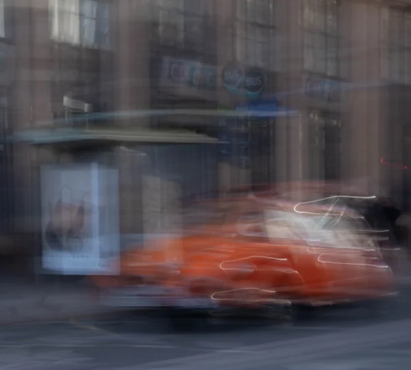 Alice · 03/01/2026 · 3591 x 3240 Cette photographie capture un sujet flou en mouvement, probablement un véhicule (comme une voiture ou un bus) en motion rapide. La composition est dynamique, avec des traits lumineux suggérant un effet de vitesse. Le cadrage est serré, centré sur le sujet principal, avec des éléments urbains en arrière-plan floutés.Les couleurs dominantes sont des teintes chaudes (orange, rouge) contrastant avec des tons froids et neutres (gris, bleu). La lumière semble naturelle mais accentuée par le mouvement, créant une ambiance cinétique et moderne. Le style évoque une approche artistique, presque abstraite, mettant l'accent sur l'énergie et la vitesse.