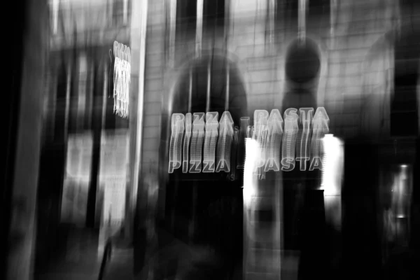 Xavier · 30/10/2025 · 4096 x 2731 Cette photographie en noir et blanc met en scène deux personnes floues, dont l’une porte un gilet pare-balles chargé de plaques métalliques. Le sujet principal semble être cette personne, suggérant une ambiance de tension ou de sécurité.La composition utilise un cadrage serré, avec un flou d’arrière-plan qui accentue le mystère. La lumière est tamisée, créant des contrastes marqués et une atmosphère sombre et dramatique. Les tons dominants sont les gris et noirs, renforçant le côté sombre et intense.Le style rappelle le photojournalisme ou un documentaire, évoquant une ambiance réaliste et immersive.