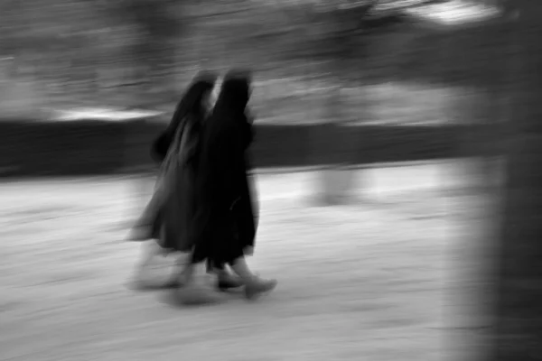 Xavier · 30/10/2025 · 4096 x 2731 Cette photographie montre un sujet principal flou, probablement une personne en mouvement, vêtue d’une longue robe sombre. La composition est dynamique, avec un cadrage serré et une impression de vitesse due au flou de mouvement. La lumière est tamisée, créant des contrastes doux.Les couleurs dominantes sont les tons de gris, typiques d’une photo en noir et blanc. Le style est artistique et expressif, évoquant une ambiance mystérieuse et onirique. L’effet de flou renforce le sentiment de mouvement et d’éphémère.