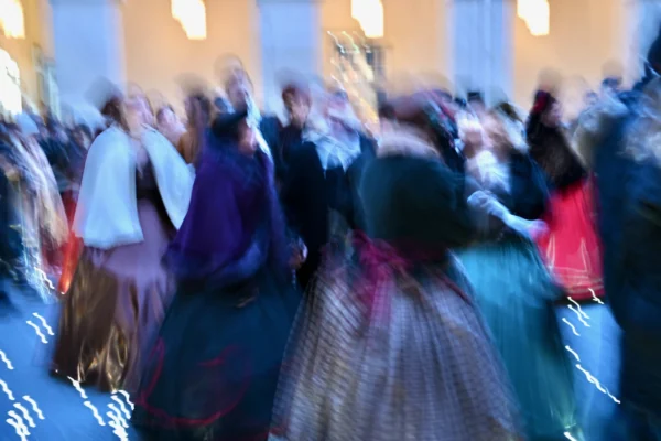 Xavier · 30/10/2025 · 4096 x 2731 Cette photographie capture une scène de danse collective floue, suggérant un mouvement dynamique. Le sujet principal est la foule en action, vêtue de tenues traditionnelles colorées. La composition, centrée sur les danseurs, utilise un cadrage serré qui accentue l’énergie du groupe.Les couleurs dominantes sont les teintes vives des vêtements : bleus, rouges et verts. La lumière, douce et tamisée, crée une ambiance chaleureuse et festive. Le style, avec son flou artistique, évoque une impression de vitesse et de joie collective, renforçant une ambiance festive et traditionnelle.