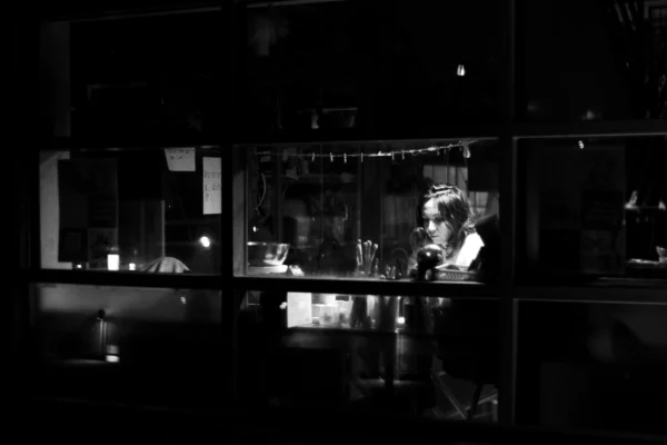 Fabienne · 14/01/2026 · 4281 x 2854 Cette photographie en noir et blanc capture une scène intimiste dans un bar ou un restaurant. Le sujet principal semble être les deux personnes assises à une table, partiellement éclairées.La composition est centrée sur ces individus, avec un cadrage serré qui isole leur espace. Les lumières tamisées créent une ambiance chaleureuse et mystérieuse, mettant en valeur les contours et les ombres. Les couleurs dominantes sont les nuances de gris, renforçant l'atmosphère nocturne et sophistiquée. Le style est documentaire et légèrement artistique, évoquant une ambiance contemplative et élégante.
