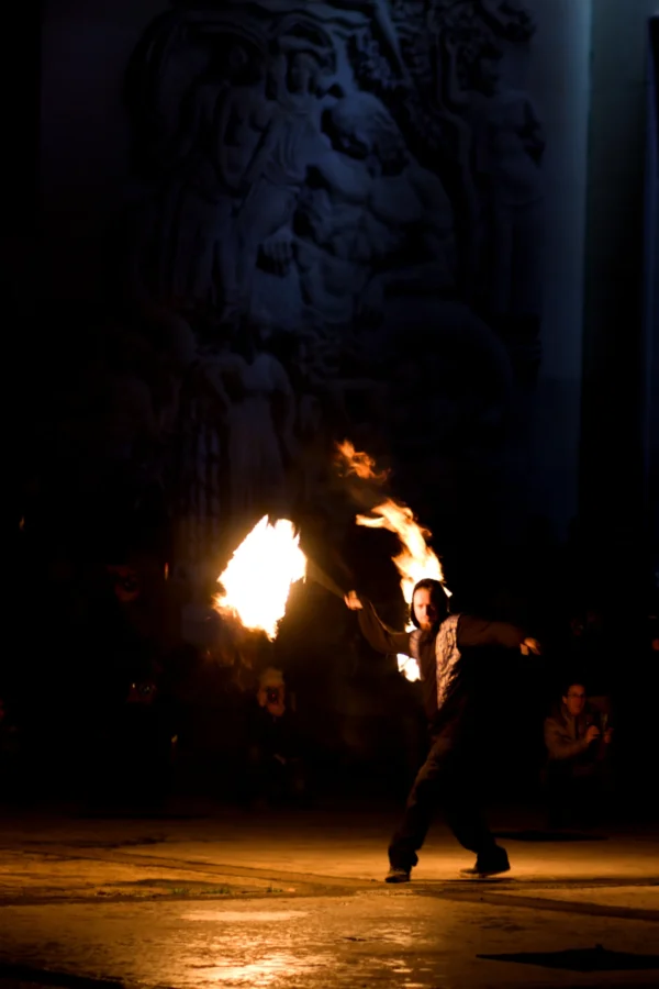 Fabienne · 24/01/2026 · 2052 x 3078 Cette photographie capture un artiste manipulant des **boules de feu** lors d’un spectacle nocturne. Le **sujet principal** est le performeur, en mouvement, éclairé par les flammes.La **composition** est dynamique, avec un **cadrage serré** sur l’artiste, mettant en valeur son action. L’**ambiance** est mystérieuse et intense, renforcée par la **lumière vive des flammes** contrastant avec l’obscurité environnante.Les **couleurs dominantes** sont les teintes chaudes des feux (oranges, jaunes) sur un fond sombre. Le **style** est réaliste et captif, évoquant une scène spectaculaire et théâtrale.