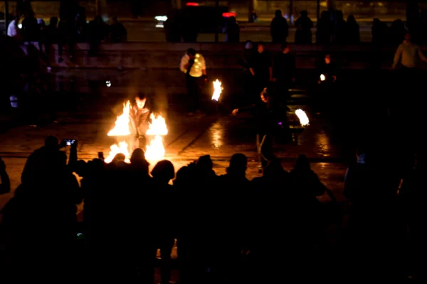 Fabienne · 24/01/2026 · 4239 x 2826 Cette photographie capture une scène nocturne où le sujet principal est un feu central entouré de personnes. La composition montre un groupe serré autour des flammes, avec des silhouettes floues en arrière-plan.Le cadrage est serré sur le feu et les mains tendues vers les flammes. La lumière, vive et contrastée, provient principalement du feu, créant des éclats lumineux et des ombres marquées. Les couleurs dominantes sont les teintes chaudes des flammes (oranges, jaunes) sur un fond sombre.Le style est documentaire et spontané, évoquant une ambiance mystique et communautaire, presque rituelle.