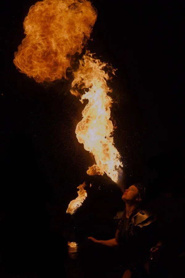 Frédéric · 1121 x 1680 Cette photographie capture un **jet de feu** émanant d’une source, probablement lors d’un spectacle de feu ou d’un rituel. Le **sujet principal** est la flamme imposante et dynamique, illuminant l’obscurité.La **composition** est verticale, avec un **cadrage serré** sur la flamme, accentuant son mouvement ascendant. Les **couleurs dominantes** sont les **tons orangés et jaunes** du feu, contrastant avec le **noir profond** de l’arrière-plan.Le **style** est dramatique et intense, créant une **ambiance mystique et puissante**, renforcée par les jeux de lumière et d’ombre.