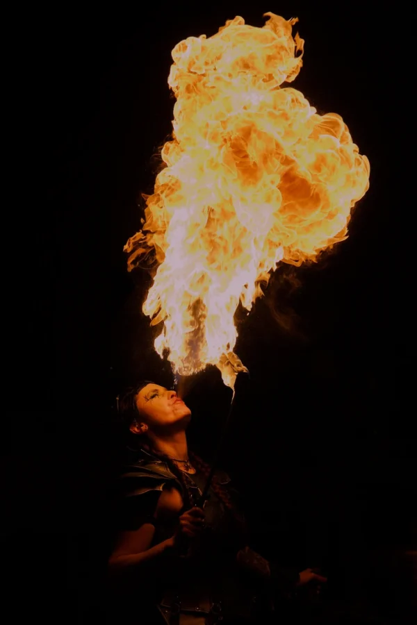 Frédéric · 1120 x 1680 Cette photographie met en scène une **flamme géante** jaillissant d’une source invisible, probablement lors d’un spectacle de feu. Le **sujet principal** est cette flamme spectaculaire, en forme de nuage lumineux et tourbillonnant.La **composition** est simple et centrée, avec un **cadrage serré** qui isole la flamme. L’**ambiance** est dramatique et intense, renforcée par l’**obscurité** de l’arrière-plan. Les **couleurs dominantes** sont les **tons chauds** (orange vif, jaune) contrastant avec le noir profond.Le **style** est réaliste et dynamique, évoquant une **atmosphère mystique et puissante**.