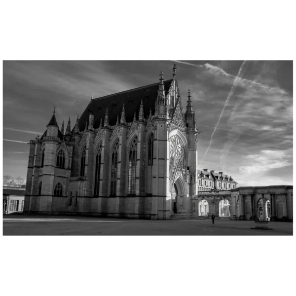 Marc Lavorata · 15/01/2026 · 1823 x 1823 Cette photographie met en scène une **cathédrale gothique** comme sujet principal, probablement Saint-Pierre de Beauvais. La **composition** est symétrique, avec une perspective frontale qui souligne les tours et les arcs-boutants. Le **cadrage** est serré, capturant l'ensemble de la façade.La **lumière** est douce et contrastée, typique d’un cliché en noir et blanc, accentuant les ombres et les détails architecturaux. Les **couleurs dominantes** sont les nuances de gris, renforçant le côté dramatique et historique.Le **style** est photographique classique, avec une ambiance **solennelle et majestueuse**, évoquant la grandeur et la permanence de l'architecture gothique.