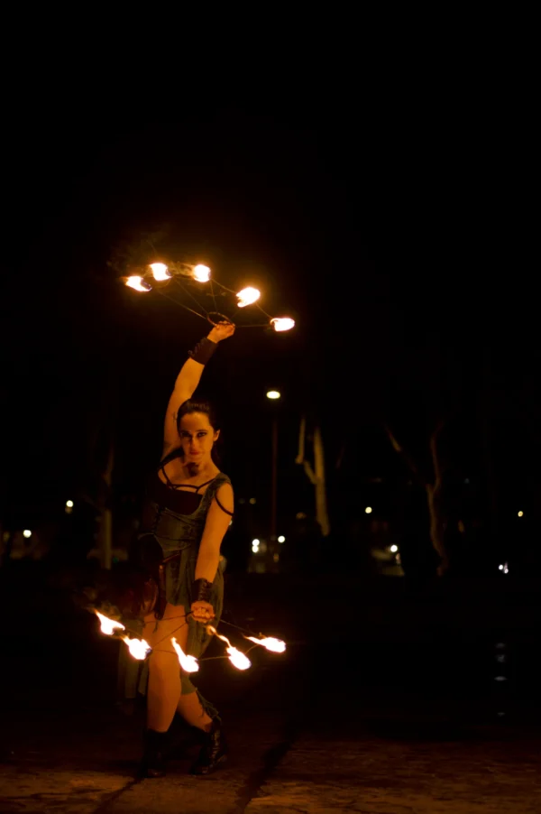 Thomas · 24/01/2026 · 2048 x 3080 Cette photographie met en scène une personne réalisant un numéro de feu avec des massues enflammées. Le sujet principal est au centre, en mouvement dynamique, avec des flammes lumineuses formant des arcs.La composition est verticale, avec un cadrage serré qui isole le performer. Les lumières chaudes des torches dominent, créant un contraste saisissant avec l’obscurité ambiante. Les couleurs principales sont les tons orangés et jaunes des flammes, sur fond noir.Le style est artistique et captivant, évoquant une ambiance mystérieuse et théâtrale, typique des spectacles de rue ou de cirque.