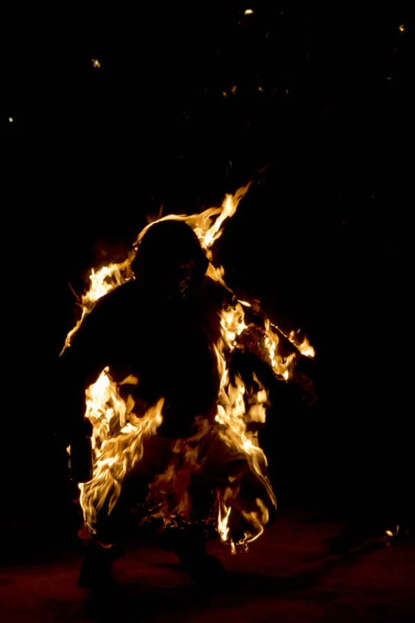 Thomas · 24/01/2026 · 2048 x 3080 Cette photographie met en scène un danseur ou un artiste enflammé, silhouette principale centrale. La composition est épurée, avec un cadrage serré qui isole le sujet sur fond noir.La lumière, vive et contrastée, provient des flammes entourant le corps, créant une ambiance dramatique. Les couleurs dominantes sont les tons orangés et jaunes des flammes, contrastant avec le noir profond de l’arrière-plan.Le style évoque l’art performatif ou le cirque, avec une touche mystique et théâtrale. L’ambiance est intense, presque hypnotique, mêlant danger et beauté.