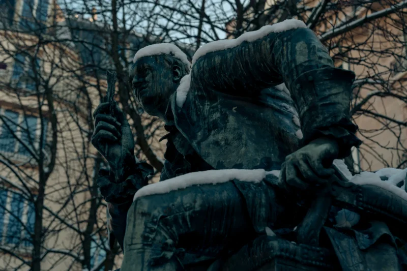 Don · 6299 x 4199 Cette photographie met en scène un groupe sculptural recouvert de neige. Le sujet principal est une statue représentant des figures humaines, probablement des soldats, en position de marche ou de soutien.La composition est serrée, centrée sur les détails des visages et des épaules. Le cadrage est rapproché, accentuant les textures et les formes.La lumière est tamisée, créant des ombres douces et une ambiance froide. Les couleurs dominantes sont les gris et les blancs, typiques d’un hiver enneigé.Le style est réaliste et sobre, évoquant une ambiance mélancolique et solennelle.
