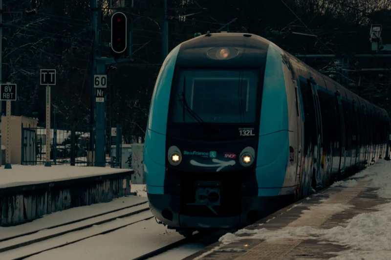 Don · 2816 x 1877 Cette photographie met en scène un **train moderne** comme sujet principal, arrêté à une gare. La **composition** est dynamique, avec le train occupant une grande partie de l’image, encadré par les voies et le quai.Le **cadrage** est serré, capturant les détails du train et son environnement immédiat. La **lumière**, tamisée et légèrement bleutée, crée une ambiance nocturne ou crépusculaire. Les **couleurs dominantes** sont des teintes froides : bleu métallique du train, gris de la gare et noir de la nuit.Le style est **réaliste et documentaire**, évoquant une **ambiance calme et industrielle**.