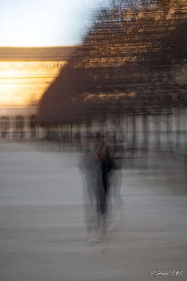 Antoine · 03/01/2026 · 1320 x 1980 Cette photographie présente un sujet principal flou, probablement une personne en mouvement près de l’eau. La composition est épurée, avec un cadrage serré sur la silhouette et le reflet dans l’eau. La lumière douce, probablement dorée, crée une ambiance tamisée et onirique. Les couleurs dominantes sont des tons froids et chauds dégradés, avec des teintes grises et des reflets dorés.Le style est artistique et abstrait, évoquant le mouvement et l’éphémère. L’ambiance est contemplative et mystérieuse, renforcée par le flou artistique.