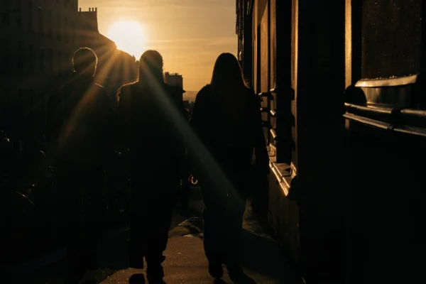 Don · 4080 x 2720 Cette photographie capture deux silhouettes en contre-jour près d’une porte entrouverte. Le **sujet principal** est l’effet de lumière et les formes floues des personnes. La **composition** joue sur les contrastes et les ombres, avec un **cadrage serré** qui isole les sujets.La **lumière**, dorée et intense, provient de l’extérieur, créant une ambiance dramatique. Les **couleurs dominantes** sont les tons chauds (oranges, jaunes) et les noirs profonds. Le **style** est réaliste et poétique, évoquant une **ambiance mystérieuse et contemplative**, presque cinématographique.