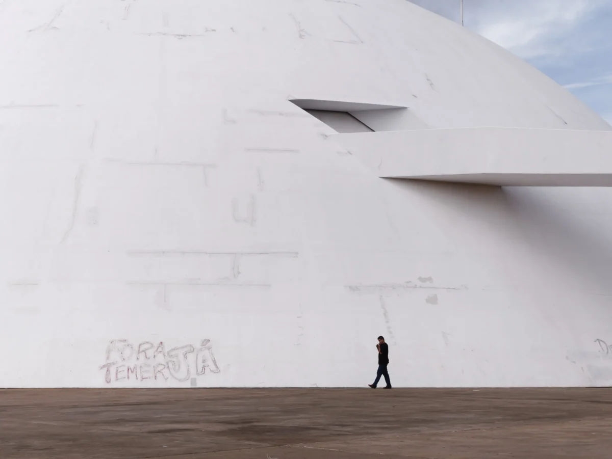 Daniel · 20/02/2018 · 4587 x 3444 Cette photographie met en scène un homme marchant devant une structure architecturale moderne et minimaliste. Le sujet principal est cet individu, isolé, en silhouette, contrastant avec l'immense mur blanc et les formes géométriques abstraites.La composition joue sur les lignes droites et les contrastes de taille entre l'homme et le bâtiment. Le cadrage est serré, centré sur l'individu et la structure. La lumière, douce et naturelle, accentue les ombres et les textures. Les couleurs dominantes sont le blanc, le gris et le noir, créant une ambiance épurée et contemplative, presque onirique. Le style est épuré, proche de la photographie artistique moderne.
