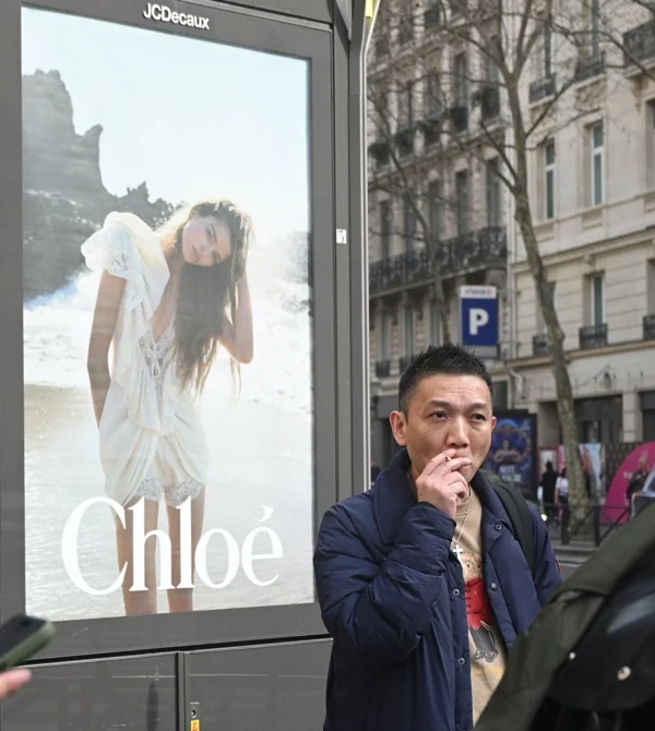 Mary P · 07/03/2026 · 2492 x 2784 Cette photographie montre un homme devant une affiche publicitaire pour la marque **Chloé**. Le sujet principal est l’affiche, mettant en scène une femme élégante en blanc sur un fond naturel. L’homme, en premier plan, semble réfléchir ou s’ennuyer.La composition juxtapose l’affiche et le passant, créant un contraste entre le glamour publicitaire et la réalité urbaine. Le cadrage est serré sur l’homme et l’affiche, avec une lumière naturelle et légèrement grise, typique d’un jour d’hiver. Les couleurs dominantes sont les tons froids (blanc, gris) et quelques touches de bleu. L’ambiance est urbaine et contemplative, mêlant mode et quotidien.