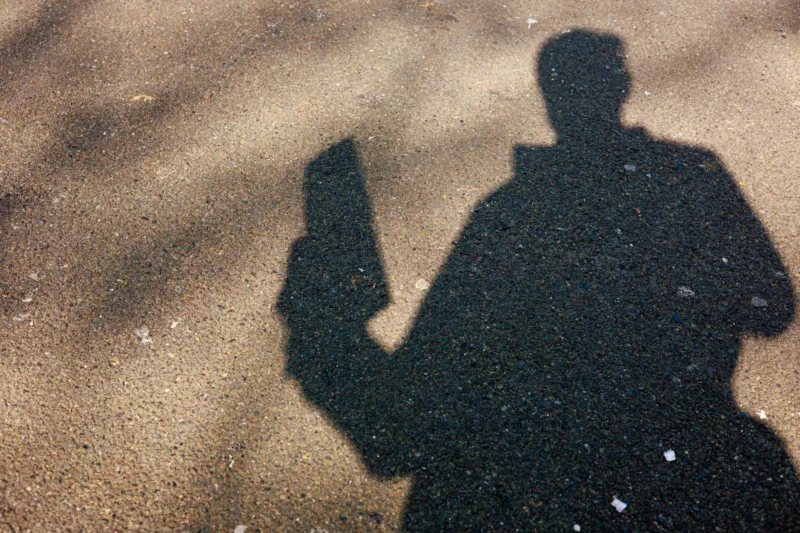 Claude · 6000 x 4000 Cette photographie capture une silhouette humaine projetée sur une surface enneigée ou givrée. Le sujet principal est cette ombre, tenant un objet ressemblant à un téléphone ou une caméra. La composition est épurée, centrée sur cette ombre contrastée.Le cadrage est serré, mettant en valeur les contours nets du sujet. La lumière semble naturelle et rasante, créant un fort contraste entre ombre et fond. Les couleurs dominantes sont le noir (silhouette) et le blanc (surface), avec des nuances grises.Le style est minimaliste et épuré, évoquant une ambiance froide et contemplative.