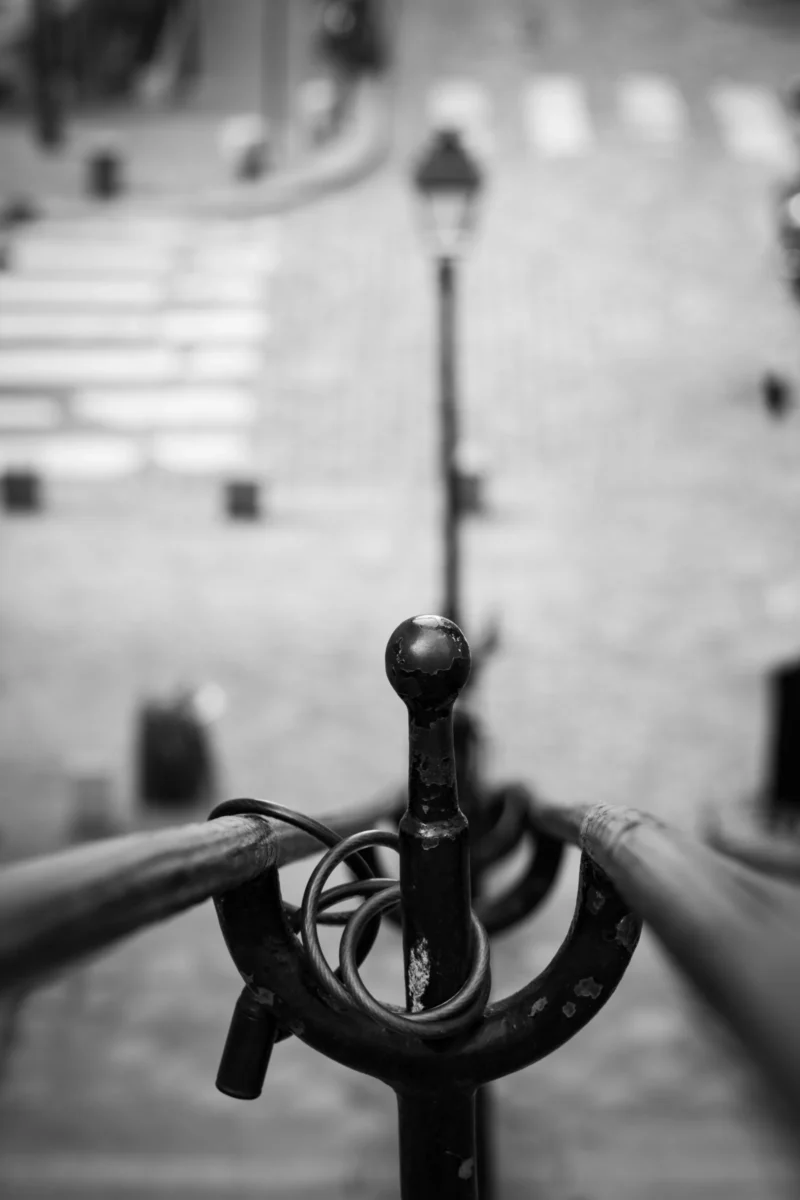 Claude · 3373 x 5060 Cette photographie met en scène un **timon de bateau**, sujet principal, avec un cadrage serré et une perspective légèrement inclinée. La composition joue sur les lignes et les textures métalliques, renforçant un effet graphique. La lumière, douce et contrastée, crée des ombres marquées, accentuant les détails. En noir et blanc, les tons varient du blanc pur aux gris profonds, ajoutant une atmosphère nostalgique et intemporelle. Le style, sobre et artistique, évoque une ambiance maritime mélancolique et mystérieuse.