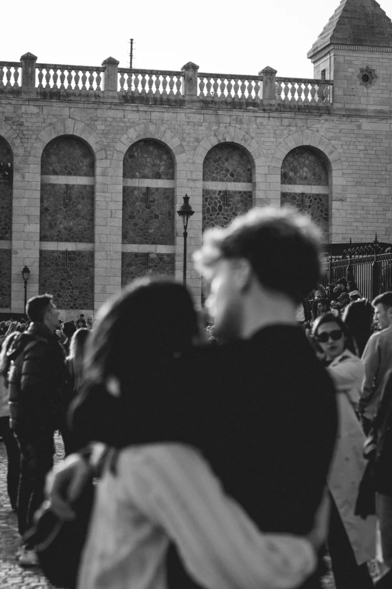 Marc Lab. · 21/03/2026 · 3115 x 4672 Cette photographie en noir et blanc capture une scène de foule urbaine. Le sujet principal est flou, suggérant des personnes en mouvement devant un bâtiment architectural imposant, probablement un lieu historique ou public.La composition met en avant les arches et les détails architecturaux en arrière-plan, créant une profondeur. Le cadrage est serré sur les individus, mais l'accent reste sur l'architecture.La lumière est naturelle, contrastée, avec des ombres marquées. Les couleurs dominantes sont les nuances de gris, renforçant l'atmosphère dramatique et intemporelle.Le style est documentaire, évoquant une ambiance à la fois animée et mélancolique.
